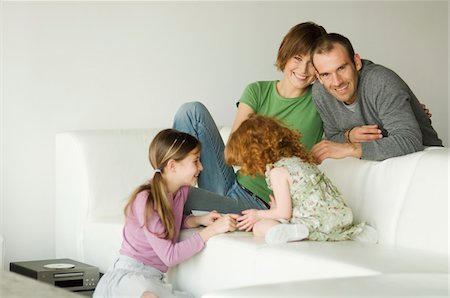 simsearch:6108-05856744,k - Smiling couple and 2 little girls in the living-room Stock Photo - Premium Royalty-Free, Code: 6108-05856589