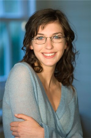 face woman glasses - Portrait of a young woman with glasses, smiling for the camera Stock Photo - Premium Royalty-Free, Code: 6108-05856503