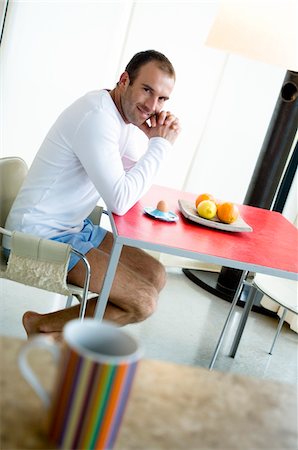 Man at breakfast table, looking at the camera, cup in foreground Foto de stock - Sin royalties Premium, Código: 6108-05856529