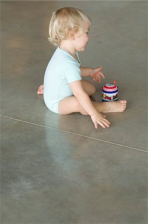 Little boy sitting on the floor, playing with music box Foto de stock - Sin royalties Premium, Código: 6108-05856648