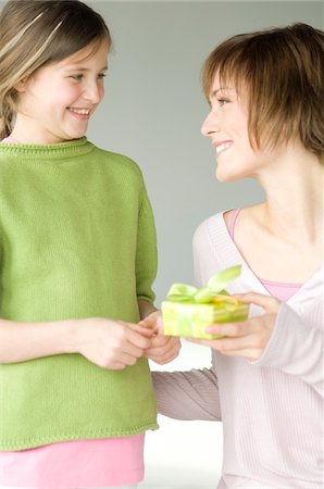 Woman giving present to little girl Stock Photo - Premium Royalty-Free, Code: 6108-05856685