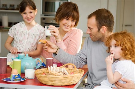 Couple et 2 petites filles prenant son petit déjeuner Photographie de stock - Premium Libres de Droits, Code: 6108-05856602