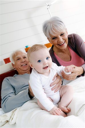 emotional grandparent - Senior couple and baby girl in bed Stock Photo - Premium Royalty-Free, Code: 6108-05856855