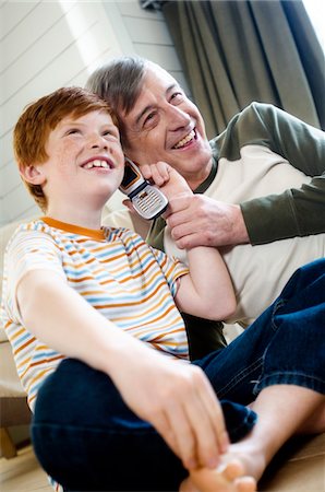 simsearch:6108-05856858,k - Lächelnd senior Man and Boy mit einem Mobiltelefon Stockbilder - Premium RF Lizenzfrei, Bildnummer: 6108-05856863