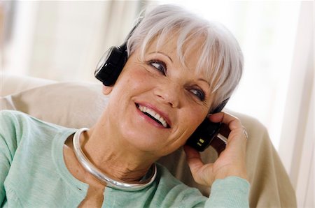 Smiling senior woman wearing headphones Stock Photo - Premium Royalty-Free, Code: 6108-05856862