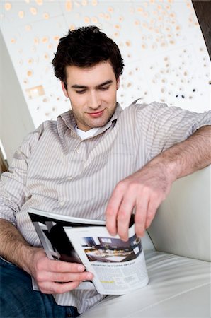 reading a magazine - Man sitting on a sofa, reading a magazine Stock Photo - Premium Royalty-Free, Code: 6108-05856813