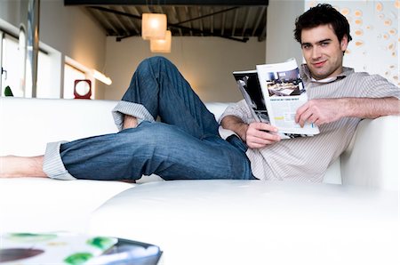 simsearch:6108-05856574,k - Man lying on a sofa, reading magazine Foto de stock - Sin royalties Premium, Código: 6108-05856832