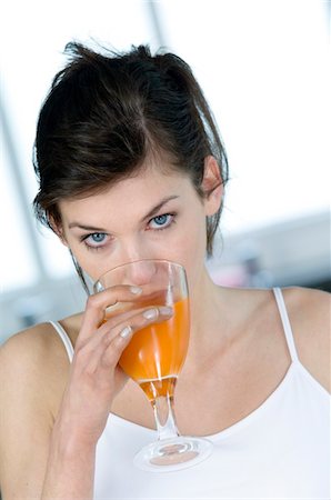 dietary supplements container - Portrait of a woman drinking orange juice Stock Photo - Premium Royalty-Free, Code: 6108-05856954