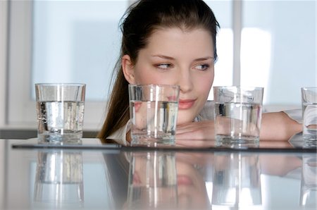 eau pétillante - Portrait d'une jeune femme regardant 4 verres d'eau Photographie de stock - Premium Libres de Droits, Code: 6108-05856969