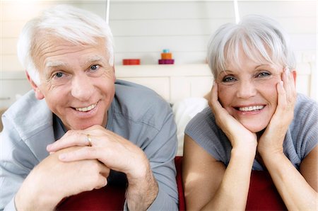 simsearch:6108-05856093,k - Senior couple allongé sur le lit, le sourire pour la caméra Photographie de stock - Premium Libres de Droits, Code: 6108-05856918