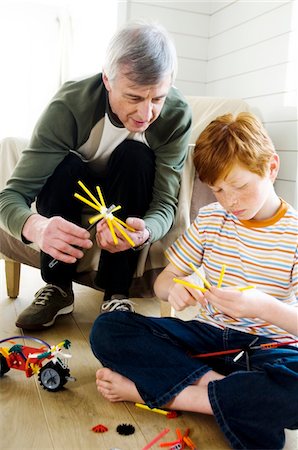 Senior man and boy playing construction game indoors Stock Photo - Premium Royalty-Free, Code: 6108-05856930