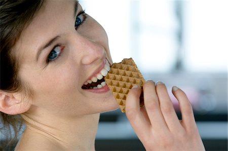 eating cookies - Portrait of a young woman eating a wafer Stock Photo - Premium Royalty-Free, Code: 6108-05856935