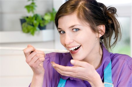 Portrait d'une jeune femme souriante, dégustation alimentaire Photographie de stock - Premium Libres de Droits, Code: 6108-05857063