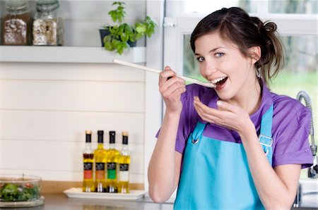 Jeune femme souriante, dégustation de produits alimentaires Photographie de stock - Premium Libres de Droits, Code: 6108-05857065