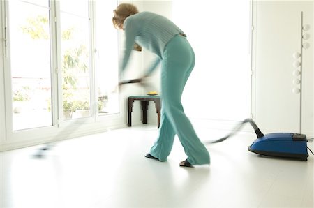 female vacuuming - Woman vacuuming in living-room Stock Photo - Premium Royalty-Free, Code: 6108-05857079