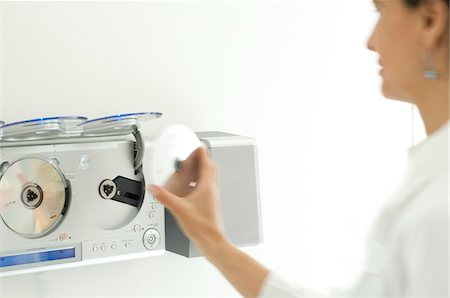 stereo - Woman using a CD player Stock Photo - Premium Royalty-Free, Code: 6108-05857084