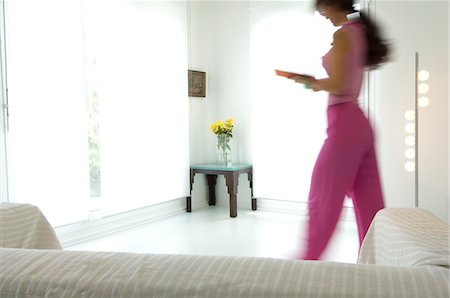 people walking into a house - Woman walking in a living-room Stock Photo - Premium Royalty-Free, Code: 6108-05857089