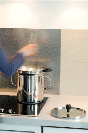 pequeno fogão portátil - Woman cooking in steam cooker Foto de stock - Royalty Free Premium, Número: 6108-05857091