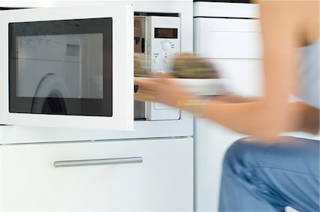 Femme à l'aide d'un four à micro-ondes, gros plan Photographie de stock - Premium Libres de Droits, Code: 6108-05857100