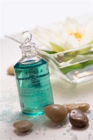 Essential oil bottle, peebles and water lily flower, close-up Foto de stock - Sin royalties Premium, Código: 6108-05857217