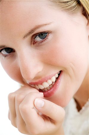 simsearch:6108-05857359,k - Portrait of a young woman smiling, lookig at the camera, indoors (studio) Stock Photo - Premium Royalty-Free, Code: 6108-05857340