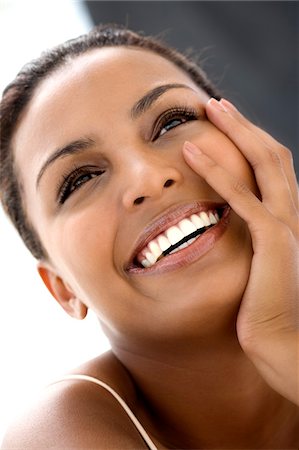 Portrait d'une jeune femme, la main sur la joue souriante Photographie de stock - Premium Libres de Droits, Code: 6108-05857392