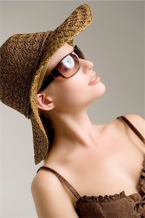 dance studio - Portrait of a young woman, brown top, straw hat, sunglasses, indoors (studio) Stock Photo - Premium Royalty-Free, Code: 6108-05857316