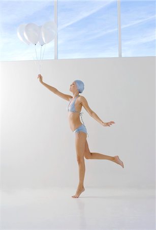 Young woman in bikini and swimming cap, holding white balloons Foto de stock - Sin royalties Premium, Código: 6108-05857448