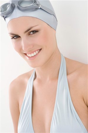 swim cap females - Portrait of a young smiling woman with bikini, swimming cap and goggles Stock Photo - Premium Royalty-Free, Code: 6108-05857482