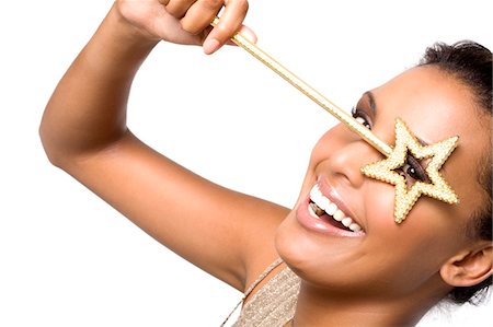 Portrait d'une jeune femme souriante regardant à travers la baguette magique Photographie de stock - Premium Libres de Droits, Code: 6108-05857417