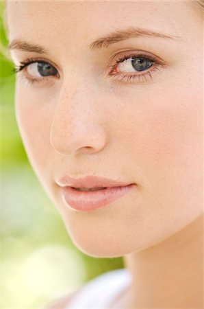 face close up serious - Portrait of young woman looking at the camera, outdoors Stock Photo - Premium Royalty-Free, Code: 6108-05857591