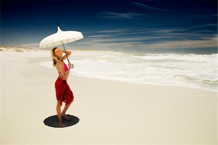 parasol - Young woman in bikini and pareo with parasol on the beach Foto de stock - Sin royalties Premium, Código: 6108-05857613