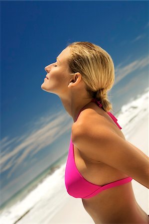 Young woman in pink bikini on beach, head back, eyes closed Foto de stock - Sin royalties Premium, Código: 6108-05857630