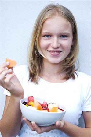 fruits salad in a container - Portrait of a teenage girl eating fruit salad Stock Photo - Premium Royalty-Free, Code: 6108-05857764