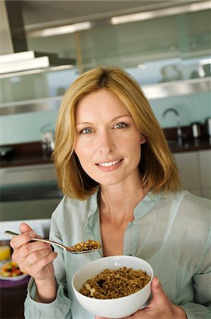 simsearch:6108-05857716,k - Portrait of a woman eating cereal Stock Photo - Premium Royalty-Free, Code: 6108-05857717