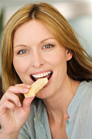 portrait eating - Portrait of a woman eating cheese Stock Photo - Premium Royalty-Free, Code: 6108-05857716