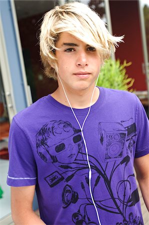 Portrait of a teenage boy with earphones Stock Photo - Premium Royalty-Free, Code: 6108-05857738