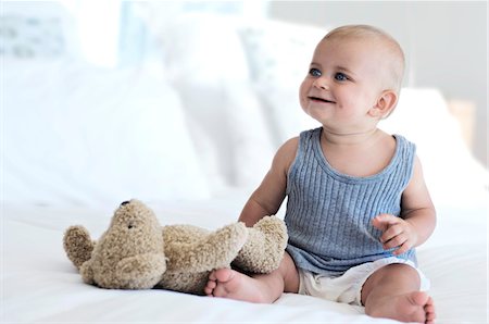 soft toy bed - Baby sitting with teddy bear, indoors Stock Photo - Premium Royalty-Free, Code: 6108-05857946