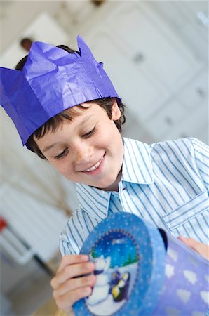 Christmas day, portrait of a little boy opening his present in a blue box, indoors Stock Photo - Premium Royalty-Free, Code: 6108-05857997