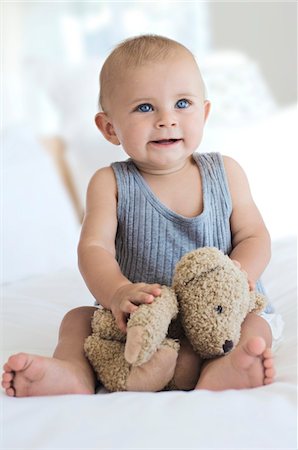 stuffed animal (toy) - Baby sitting with teddy bear, indoors Stock Photo - Premium Royalty-Free, Code: 6108-05857908