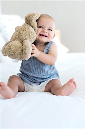 ropas para guaguas - Baby sitting with teddy bear, indoors Foto de stock - Sin royalties Premium, Código: 6108-05857919