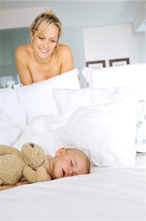 people looking tired - Mother smiling looking at her baby asleep, indoors Stock Photo - Premium Royalty-Free, Code: 6108-05857929