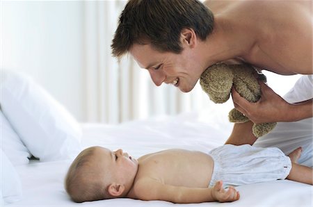 simsearch:6108-05856028,k - Father looking at his baby, lying in bed, indoors Stock Photo - Premium Royalty-Free, Code: 6108-05857932
