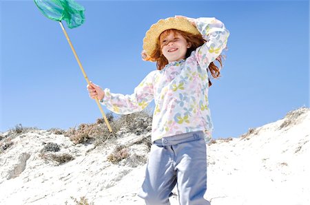 Little girl walking on the beach, holding a landing net, outdoors Stock Photo - Premium Royalty-Free, Code: 6108-05858072