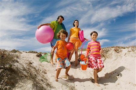 family group of people caucasian - Parents and two children walking on the beach, outdoors Stock Photo - Premium Royalty-Free, Code: 6108-05858086