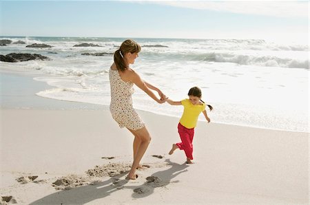 running women clothing - Mother and daughter playing on the beach, outdoors Stock Photo - Premium Royalty-Free, Code: 6108-05858140