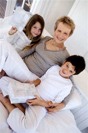 Haute femme et deux enfants tenant des cadeaux, à l'intérieur Photographie de stock - Premium Libres de Droits, Code: 6108-05858168