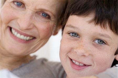 simsearch:6108-05858176,k - Senior woman and little boy smiling for the camera, indoors Stock Photo - Premium Royalty-Free, Code: 6108-05858175