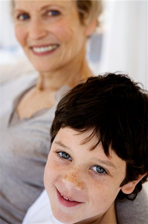 simsearch:6108-05858176,k - Senior woman and little boy smiling for the camera, indoors Stock Photo - Premium Royalty-Free, Code: 6108-05858187