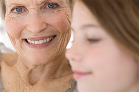 simsearch:6108-05858176,k - Senior woman smiling for the camera, little girl in foreground, indoors Stock Photo - Premium Royalty-Free, Code: 6108-05858192